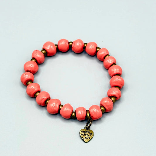 Handmade coral bead bracelet with gold spacer beads and 'Made with Love' heart charm, artisan-crafted jewelry.